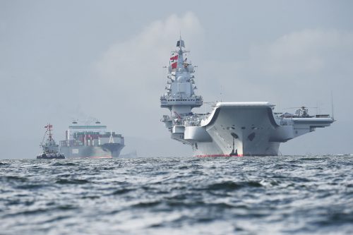 TOPSHOT - China's sole aircraft carrier, the Liaoning (R), arrives in Hong Kong waters on July 7, 2017, less than a week after a high-profile visit by president Xi Jinping. China's national defence ministry had said the Liaoning, named after a northeastern Chinese province, was part of a flotilla on a "routine training mission" and would make a port of call in the former British colony. / AFP PHOTO / Anthony WALLACE (Photo credit should read ANTHONY WALLACE/AFP/Getty Images)